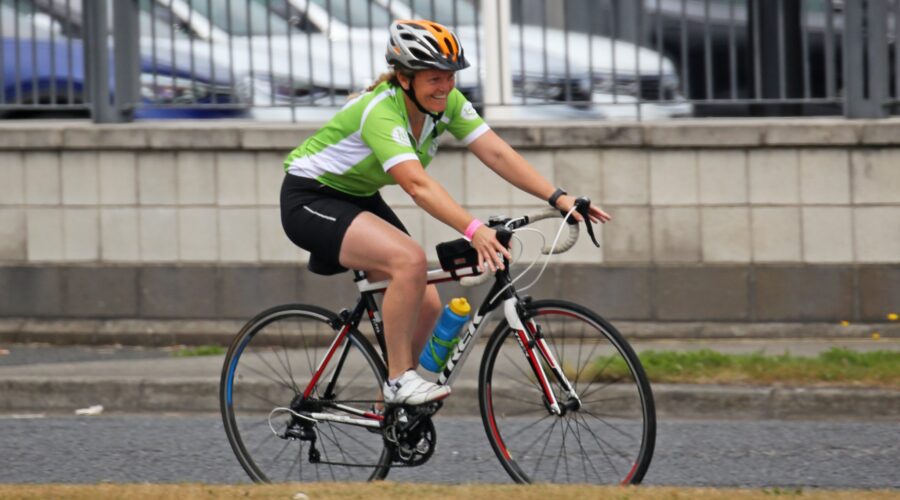 Women smiles as she cycles bike.