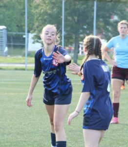 Two young soccer players high five.