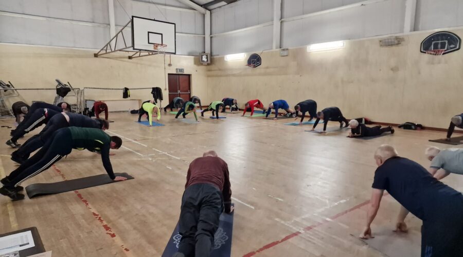 Men on the Move - Group of men do push ups on mats in gym.