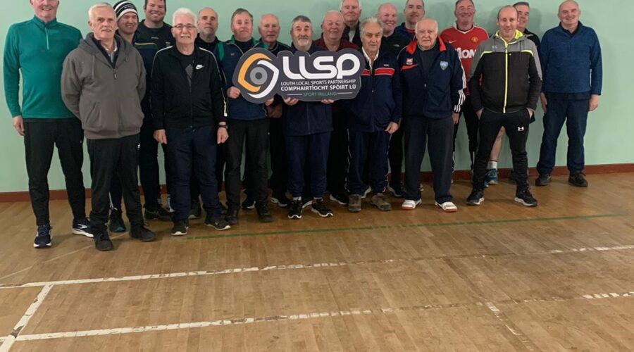 Men on the Move - Group of men stand in gym holding sign for LLSP.