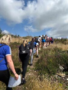 Group of girls climb trail.
