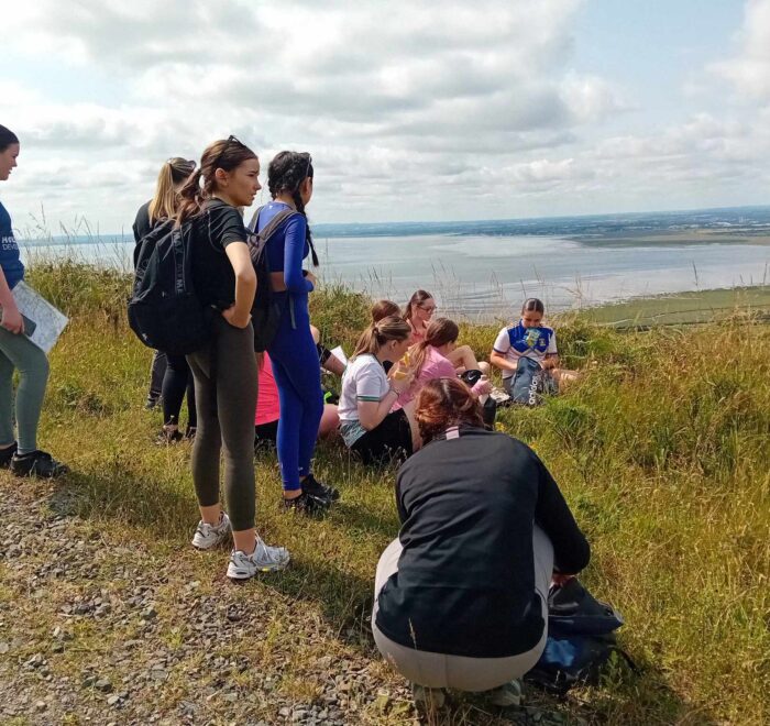 Group of girls stop for a snack on trail.