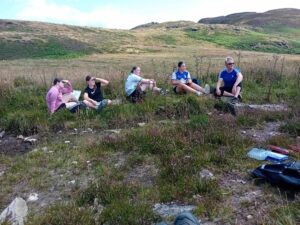 Group of five girls take a rest on trail.