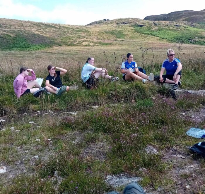 Group of five girls take a rest on trail.