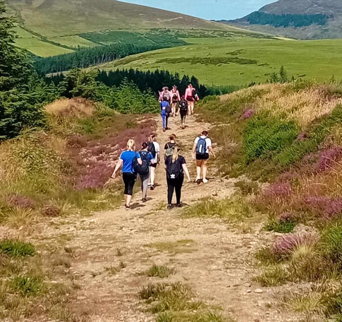 Group of girls climbing a summit trail.