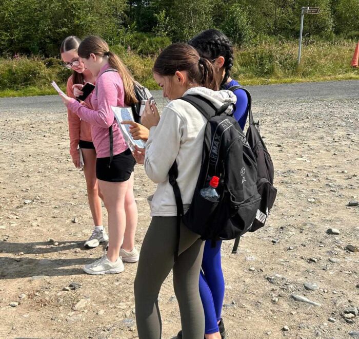 Group of four girls check maps.