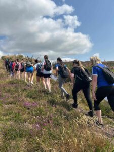 Group of girls continue uphill on trail.