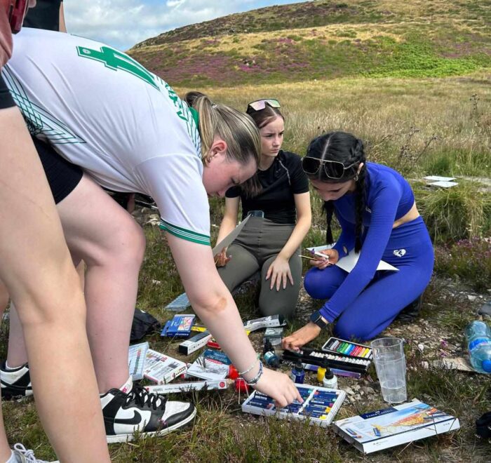Group of girls organise colouring pencils and crayons.