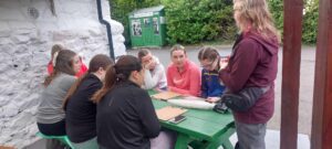 Group of girls site at green picnic bench.