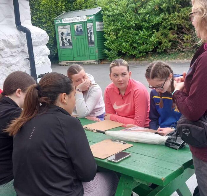 Group of girls site at green picnic bench.
