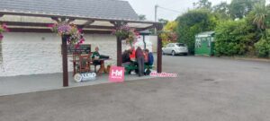 Group of girls site at green picnic bench.
