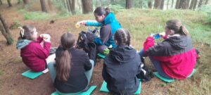 Group of girls share food while on nature trail.