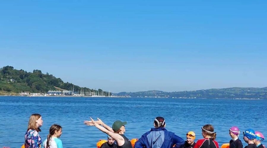 Group of girls enjoy swimming in open water.