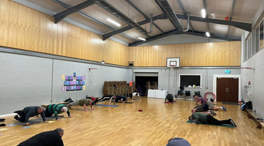 Men on the Move - Group of men do push ups on mats in gym.