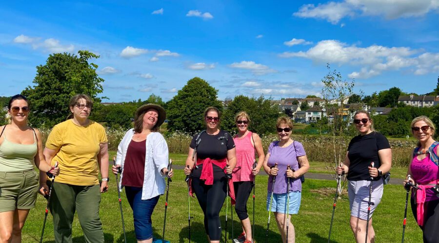 Group of women take part in nordic walking on a sunny day.