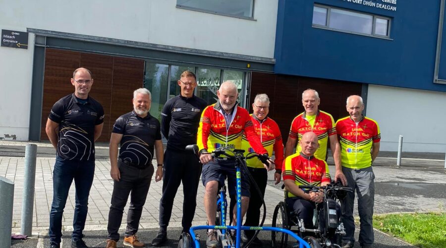 Group of men outside Dundalk Sport Centre with a wheelchair accessible bike.