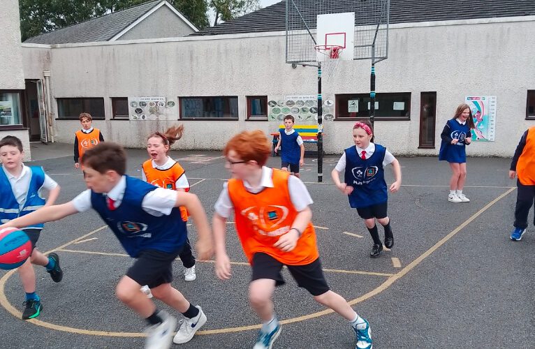 Children play basketball on an outdoor basketball court.