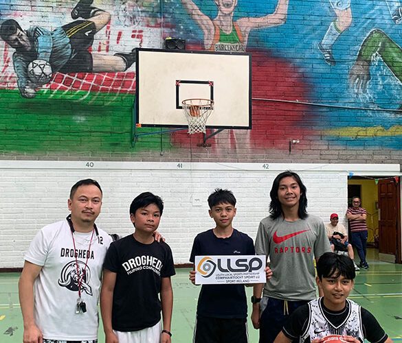 Group of men in basketball attire holding sign for LLSP.