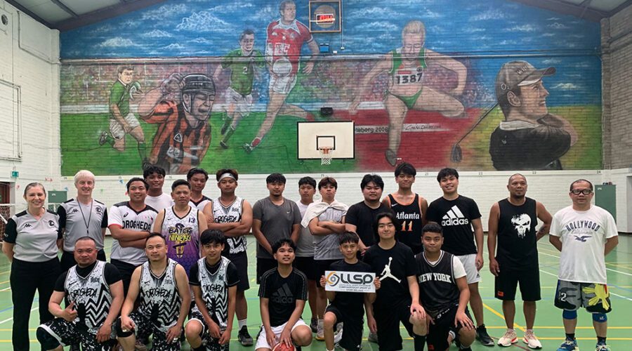 Group of men in basketball attire holding sign for LLSP.