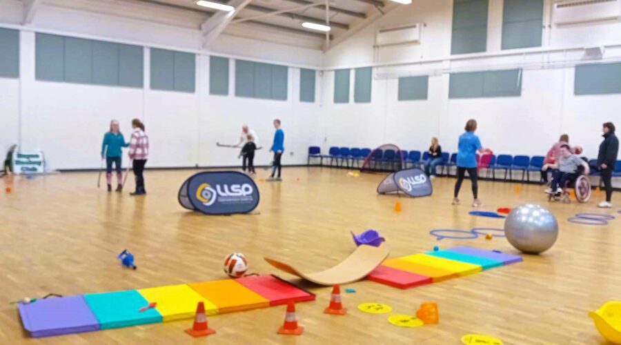 View of a gymnasium with a lot of activities set up for SportsAbility Day.