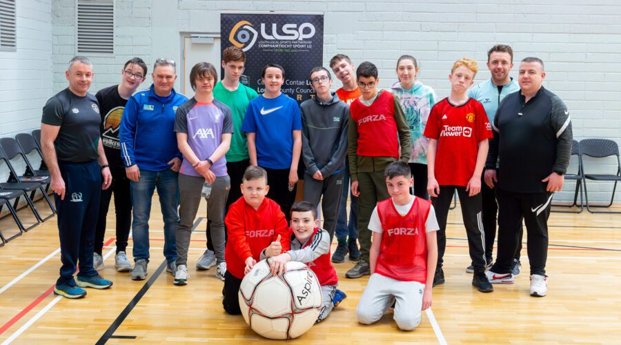 Group of people pose for group picture with a very large white ball.