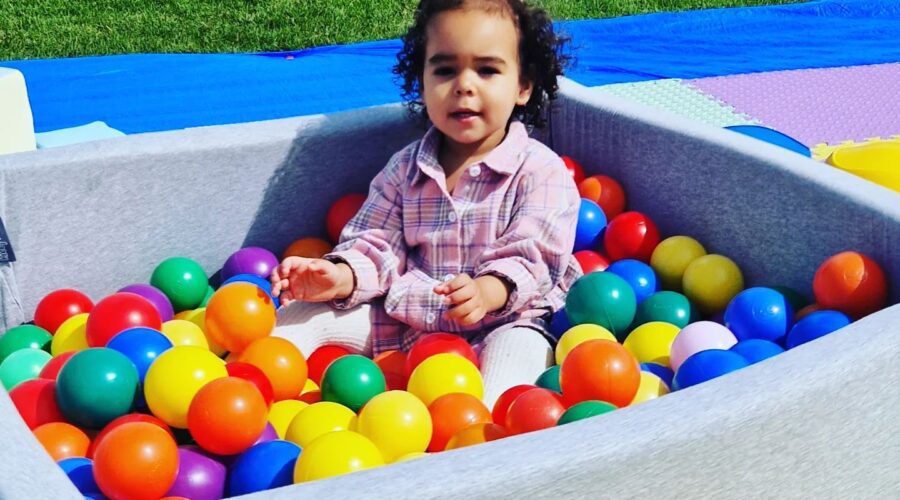 Young girl plays in a ball pit.