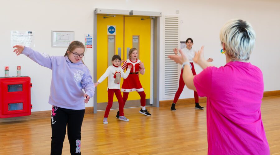 Group of people exercise in gymnasium.